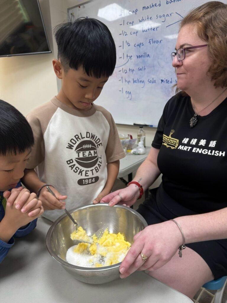 老師與國小學生一起完成手作專題並練習英文對話