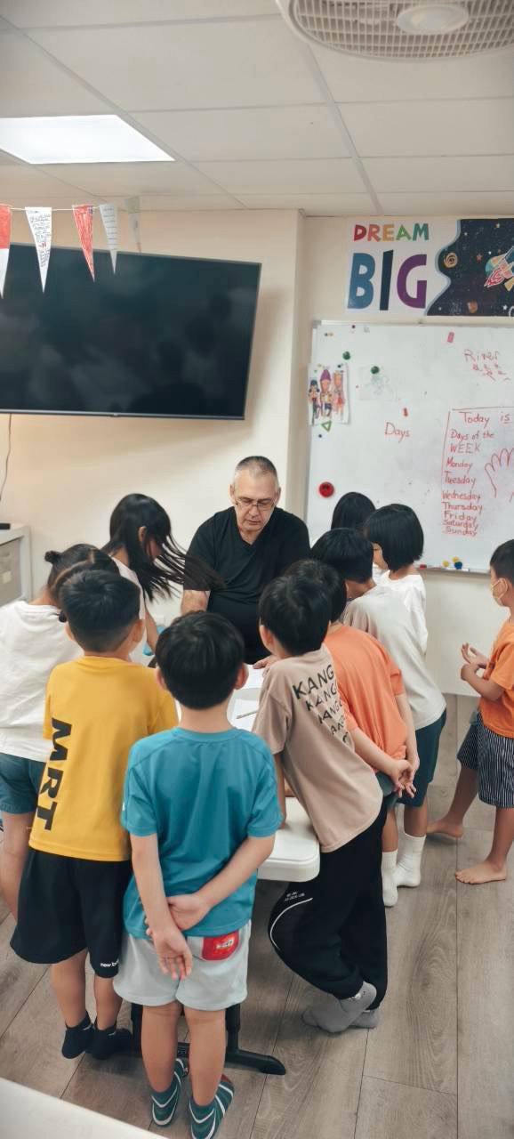 Good Good English 老師與孩子們圍桌互動，DREAM BIG 標語