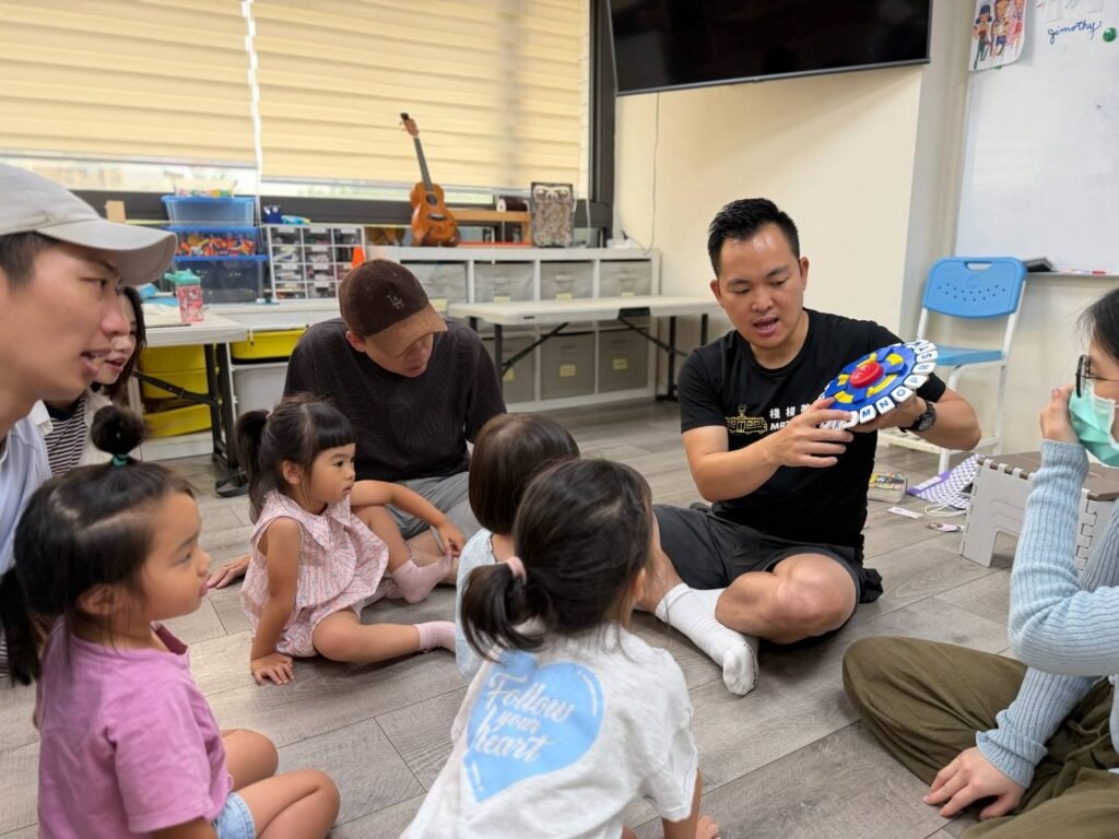 Parents and children joining in a Good Good English interactive activity